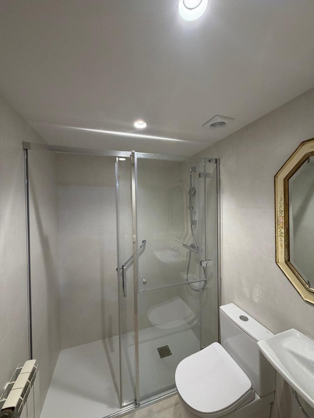 Baño terminado con pintura blanca limpia, techo y paredes sin manchas
