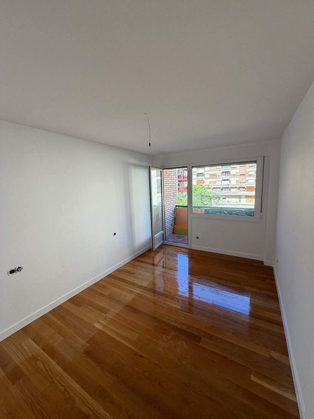 Acabado final de la habitación insonorizada con pintura blanca y suelo de madera